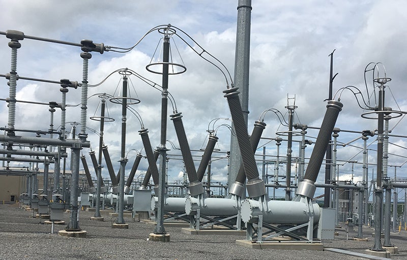 Panel switchgear AIS lengkap di gardu induk, terlihat busbar dan isolator keramik.