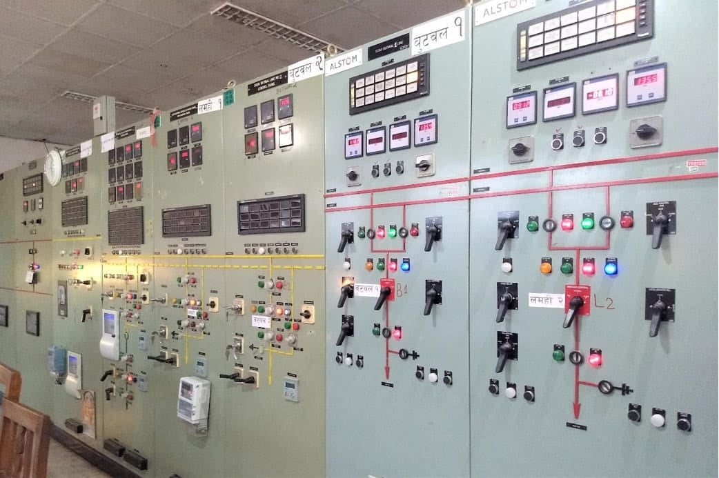 Pandangan luas ruang kontrol gardu induk dengan panel sinkronisasi