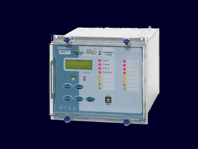 Teknisi memeriksa relay diferensial di panel kontrol substasi
