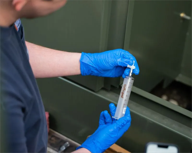 Teknisi memeriksa transformator daya besar di gardu induk, terkait pemantauan DGA.