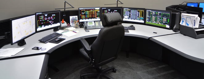 Operator memantau data ketersediaan pembangkit listrik di ruang kendali modern