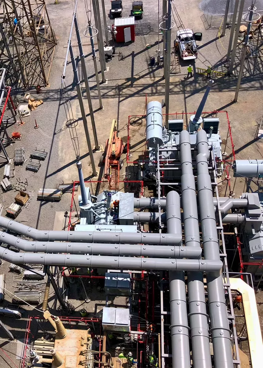 Pipa saluran fase terisolasi (IPB) berwarna perak di pembangkit listrik, close-up.