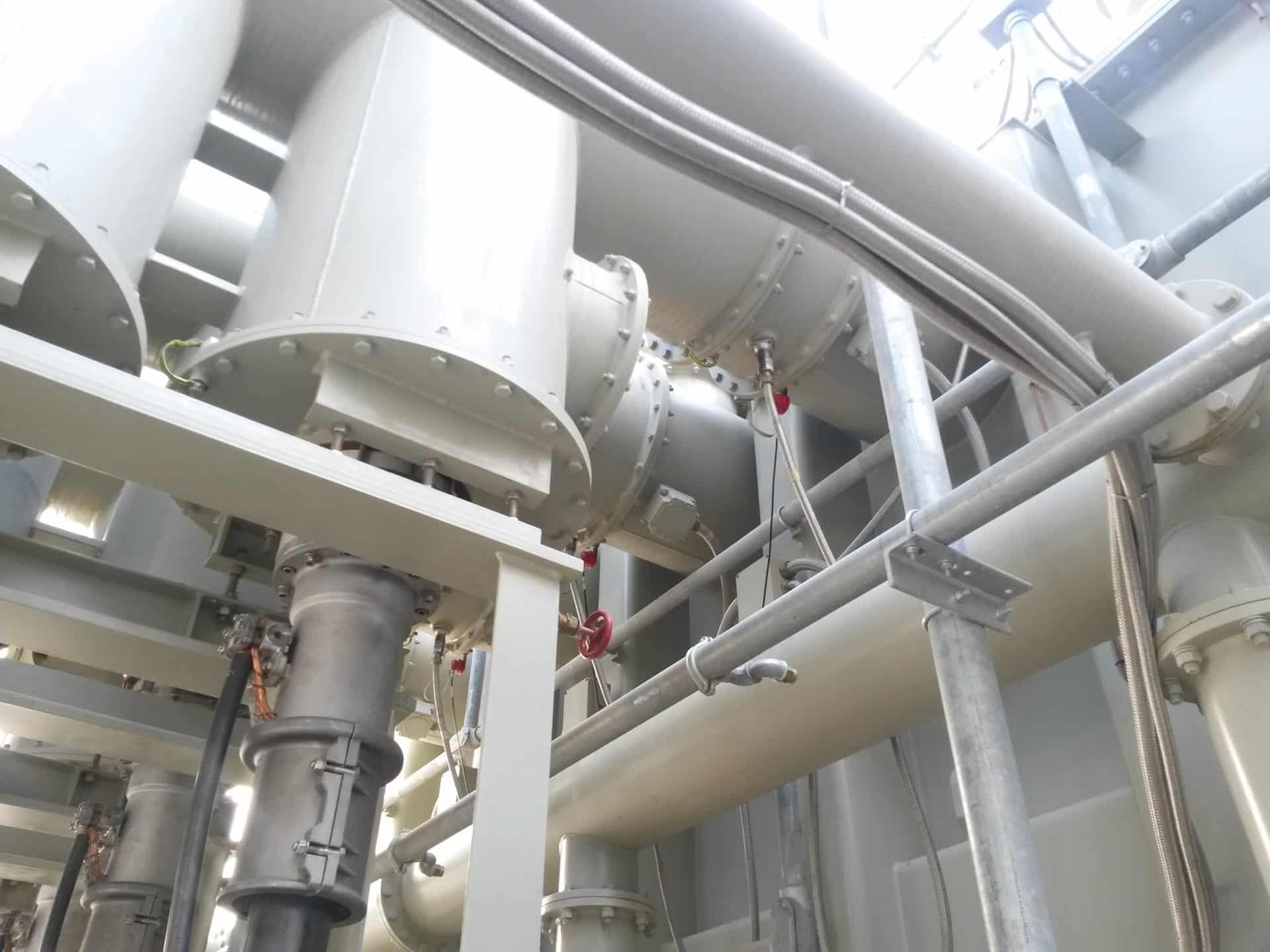 Pemasangan busduct fase terisolasi besar di gardu induk, tampak pekerja.