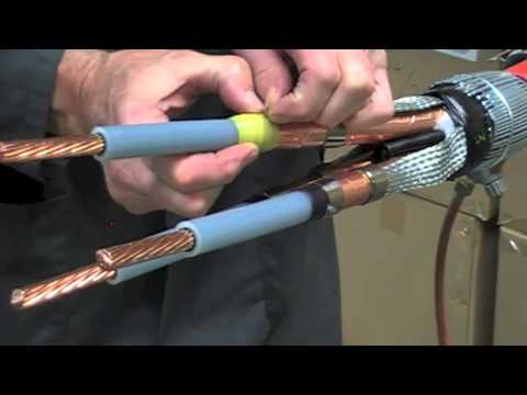 Teknisi memasang isolasi pada sambungan kabel tegangan tinggi di tiang.