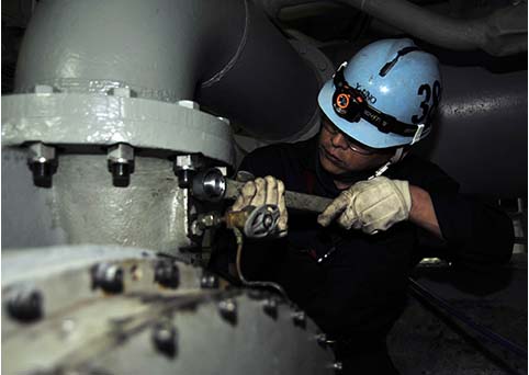 Teknisi memeriksa turbin generator besar di pembangkit listrik selama pemeliharaan terjadwal