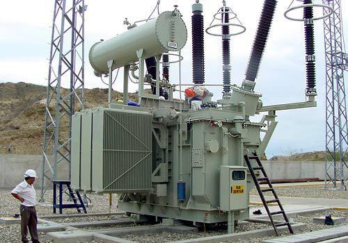 Tiga reaktor shunt besar berwarna abu-abu di gardu induk transmisi tegangan tinggi.