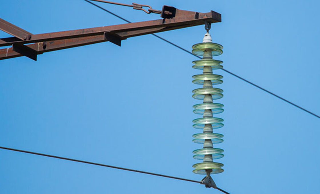 String isolator suspensi pada menara transmisi tegangan tinggi, latar langit biru